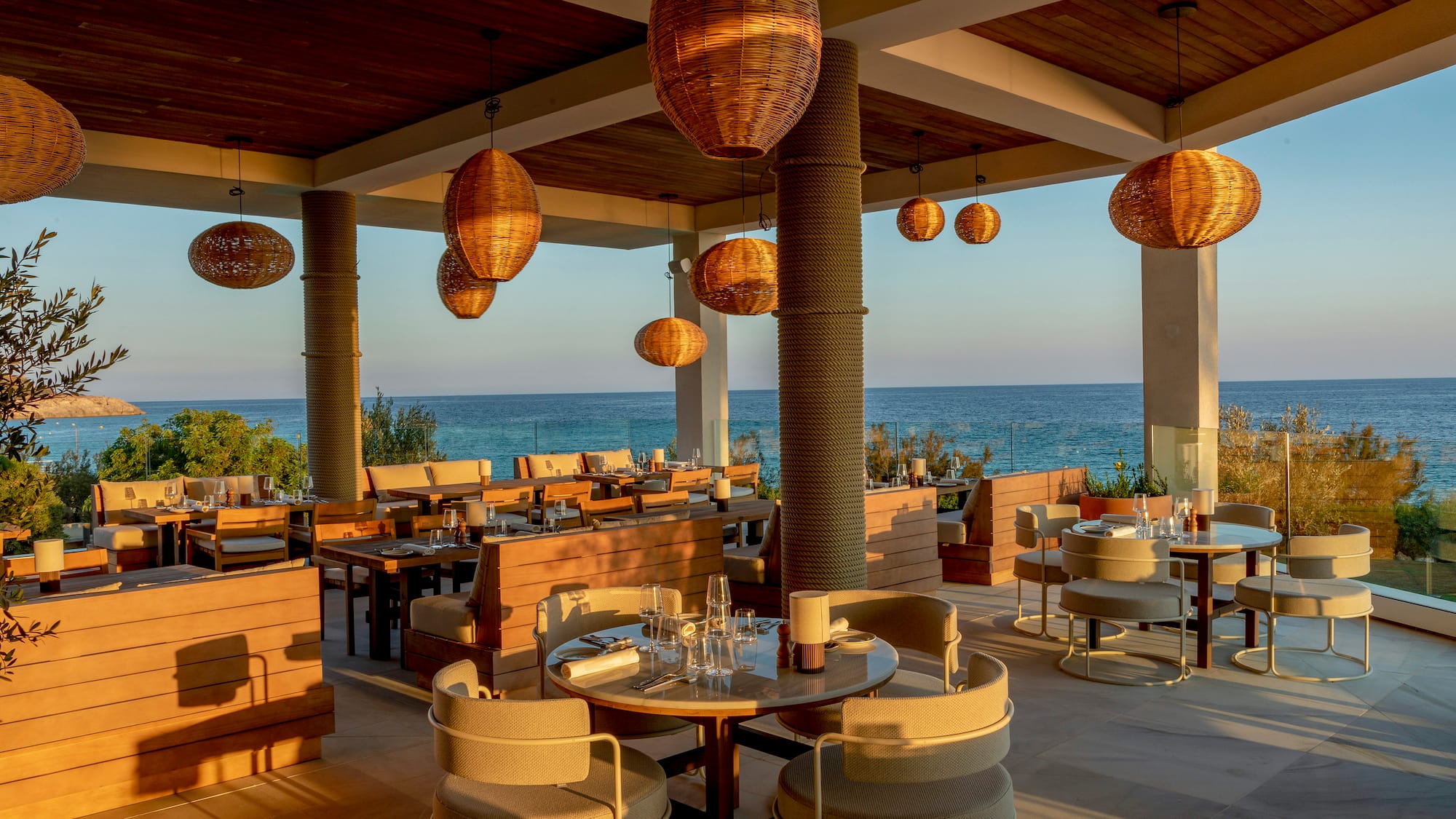 a restaurant with tables and chairs and a view of the ocean