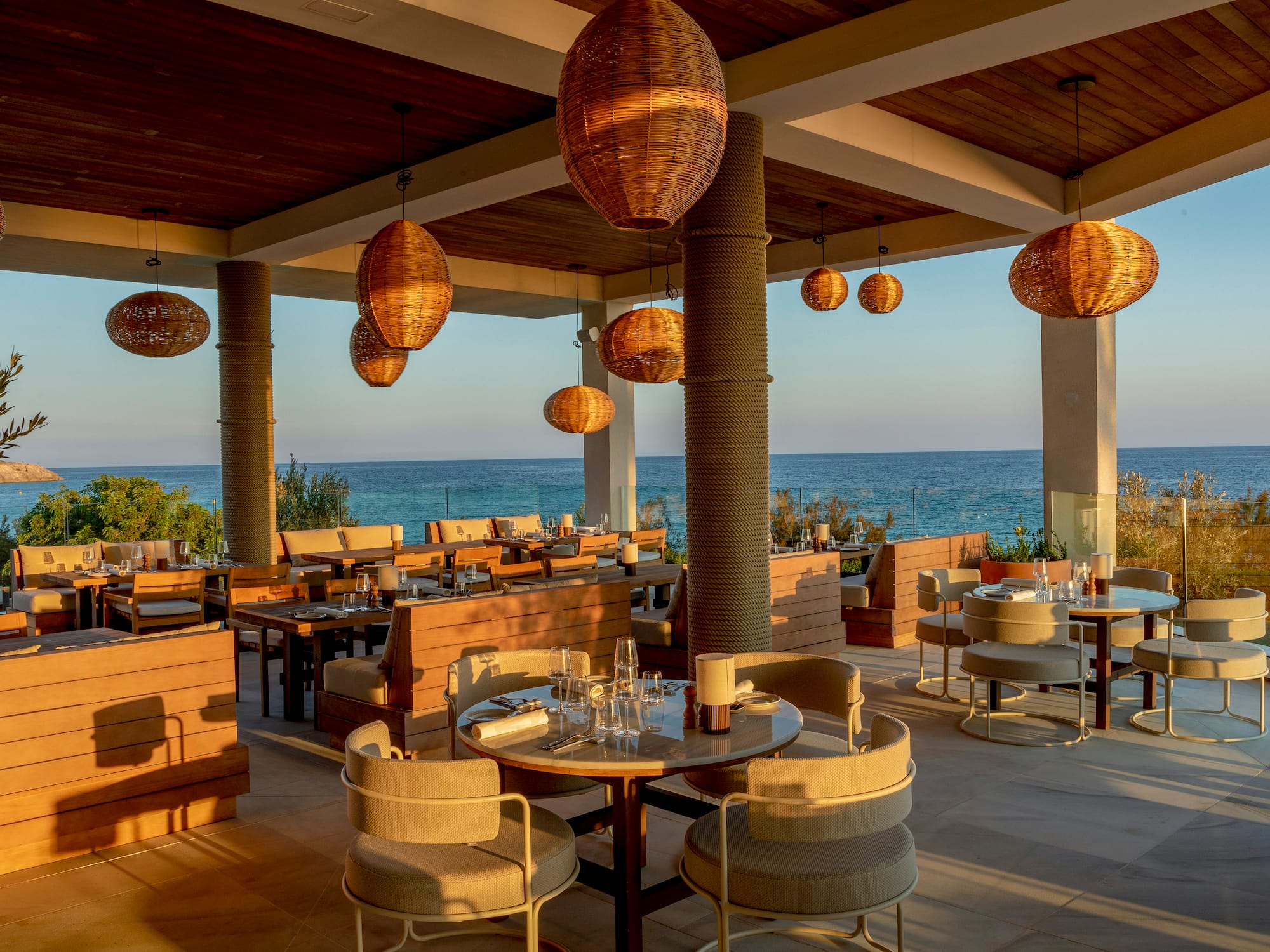 a restaurant with tables and chairs and a view of the ocean