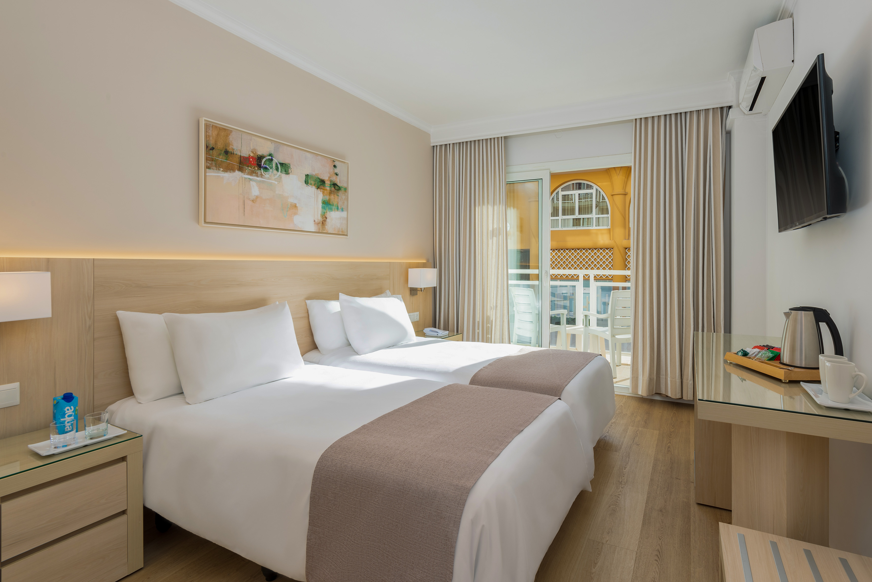 a room with two beds and a glass table