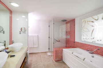 a bathroom with a glass shower and tub