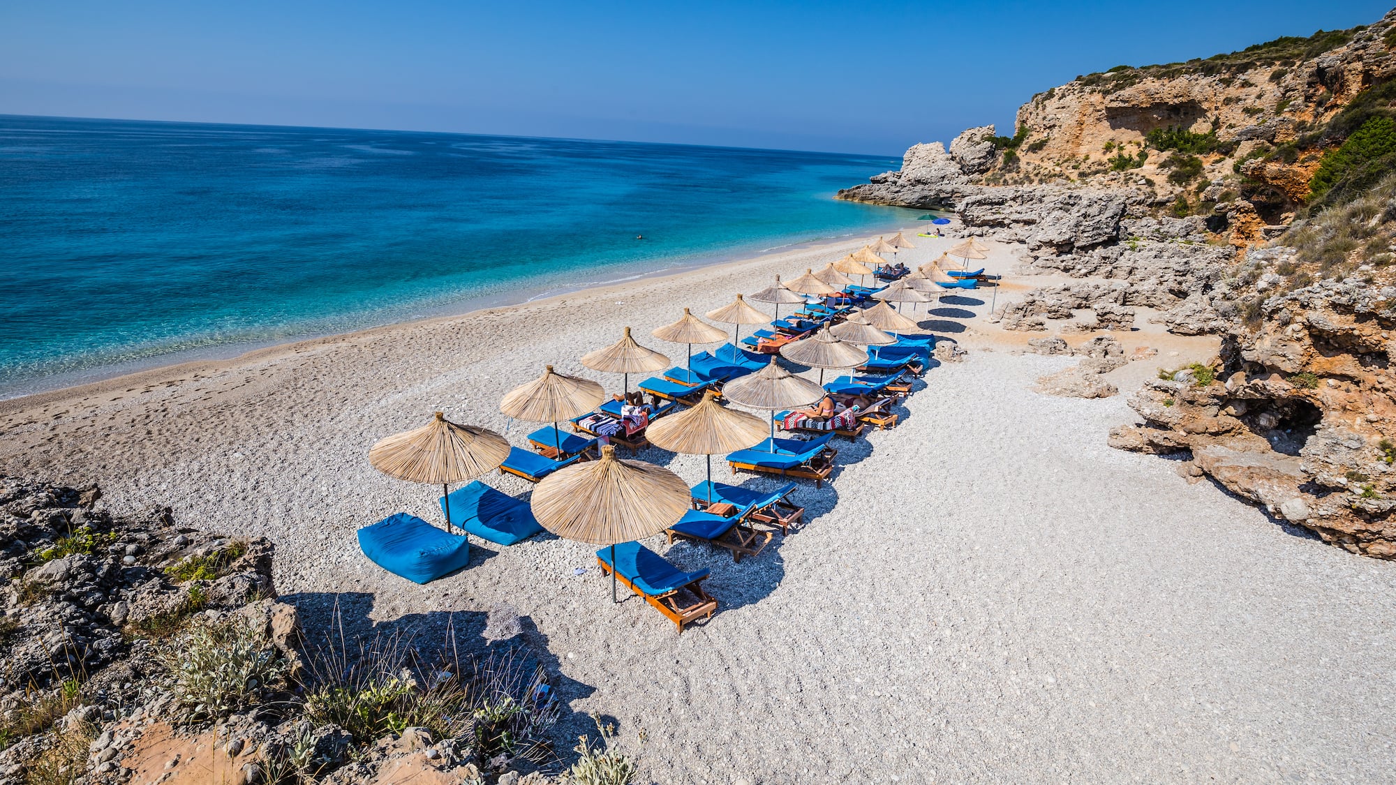 a beach with umbrellas and chairs