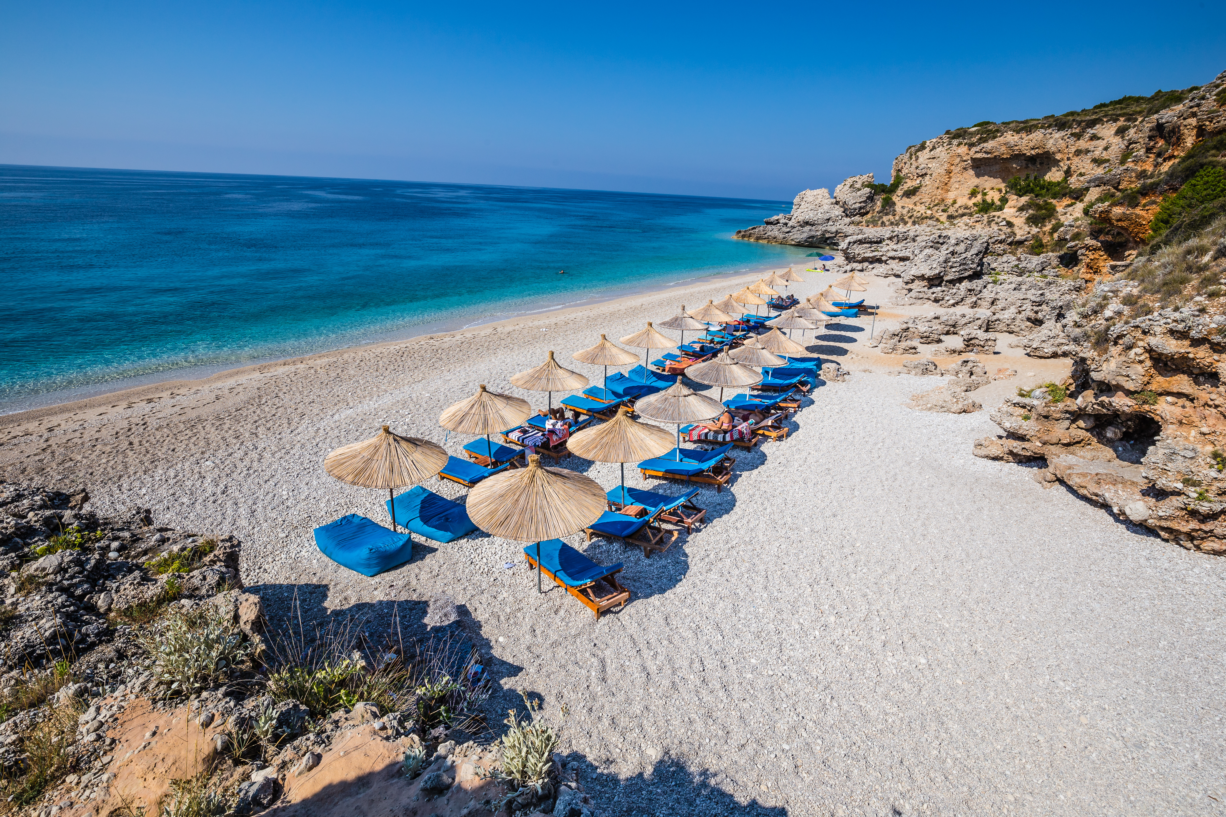 a beach with umbrellas and chairs
