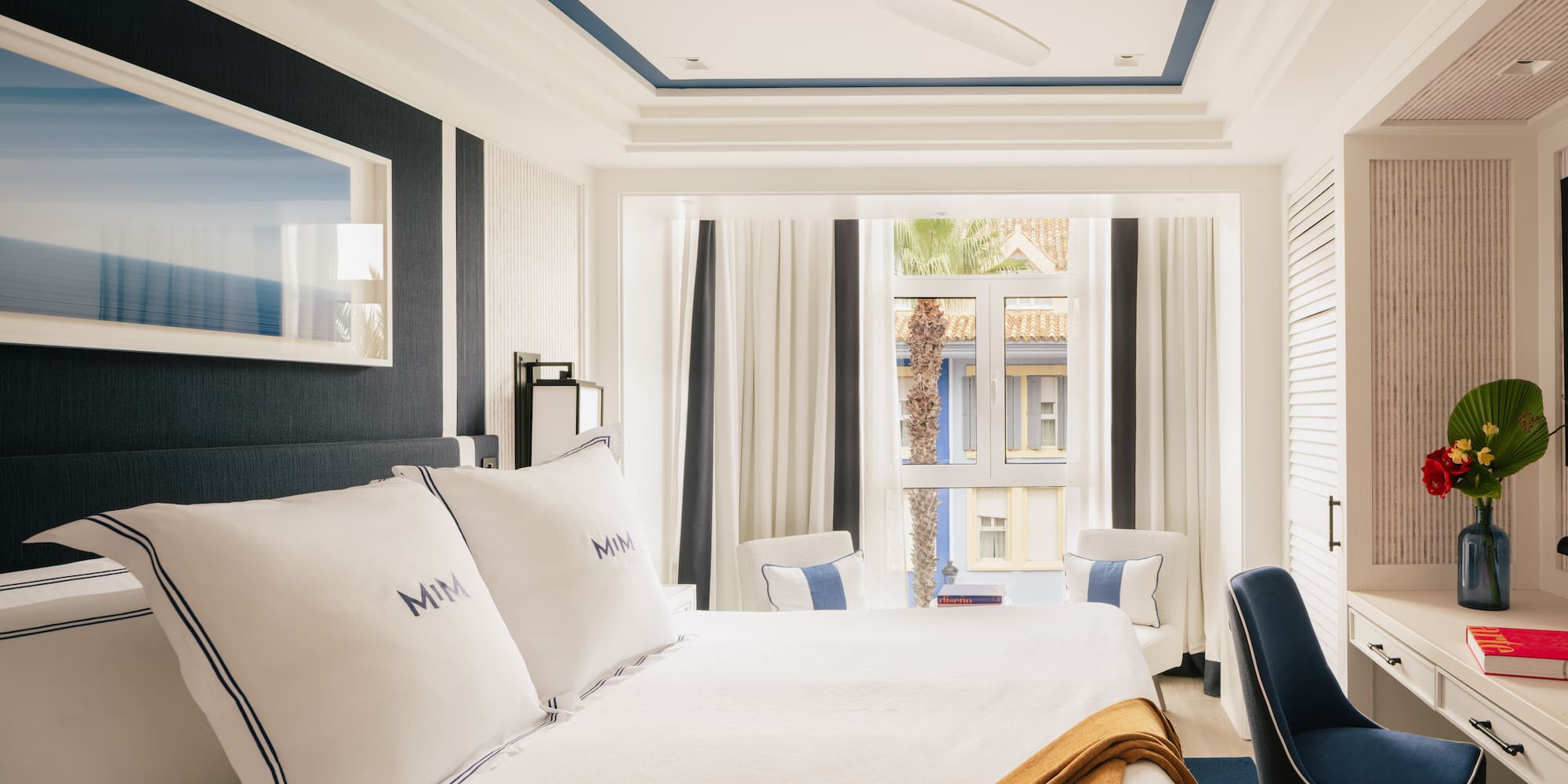 a room with a bed and chairs