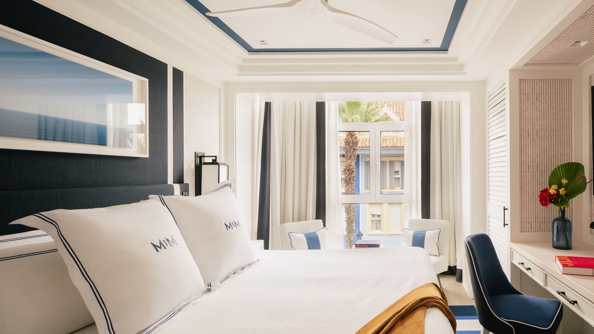 a room with a bed and chairs