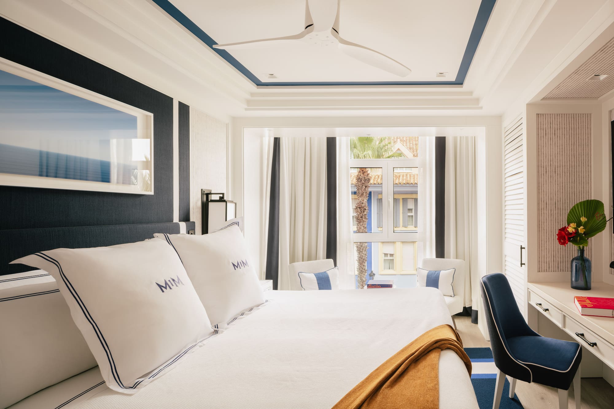 a room with a bed and chairs