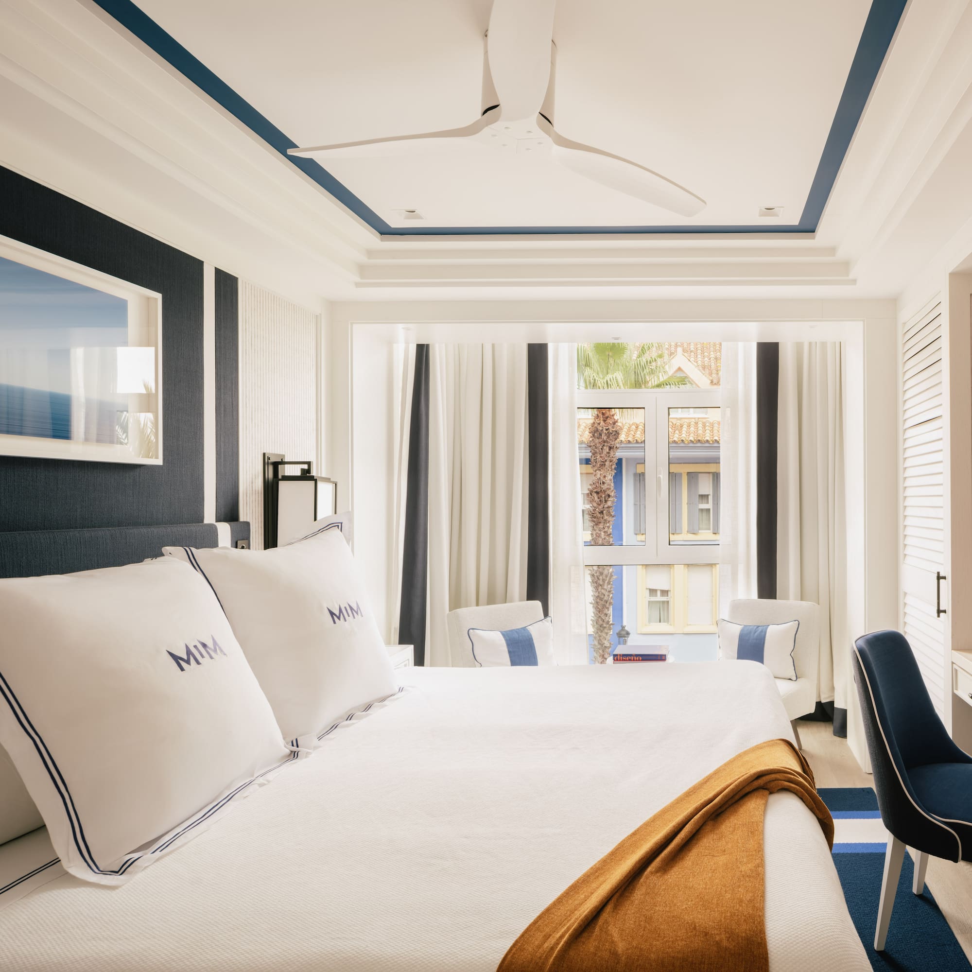 a room with a bed and chairs