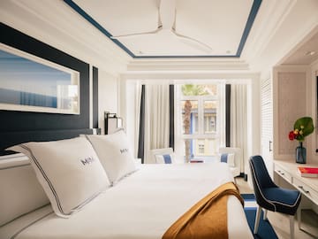 a room with a bed and chairs