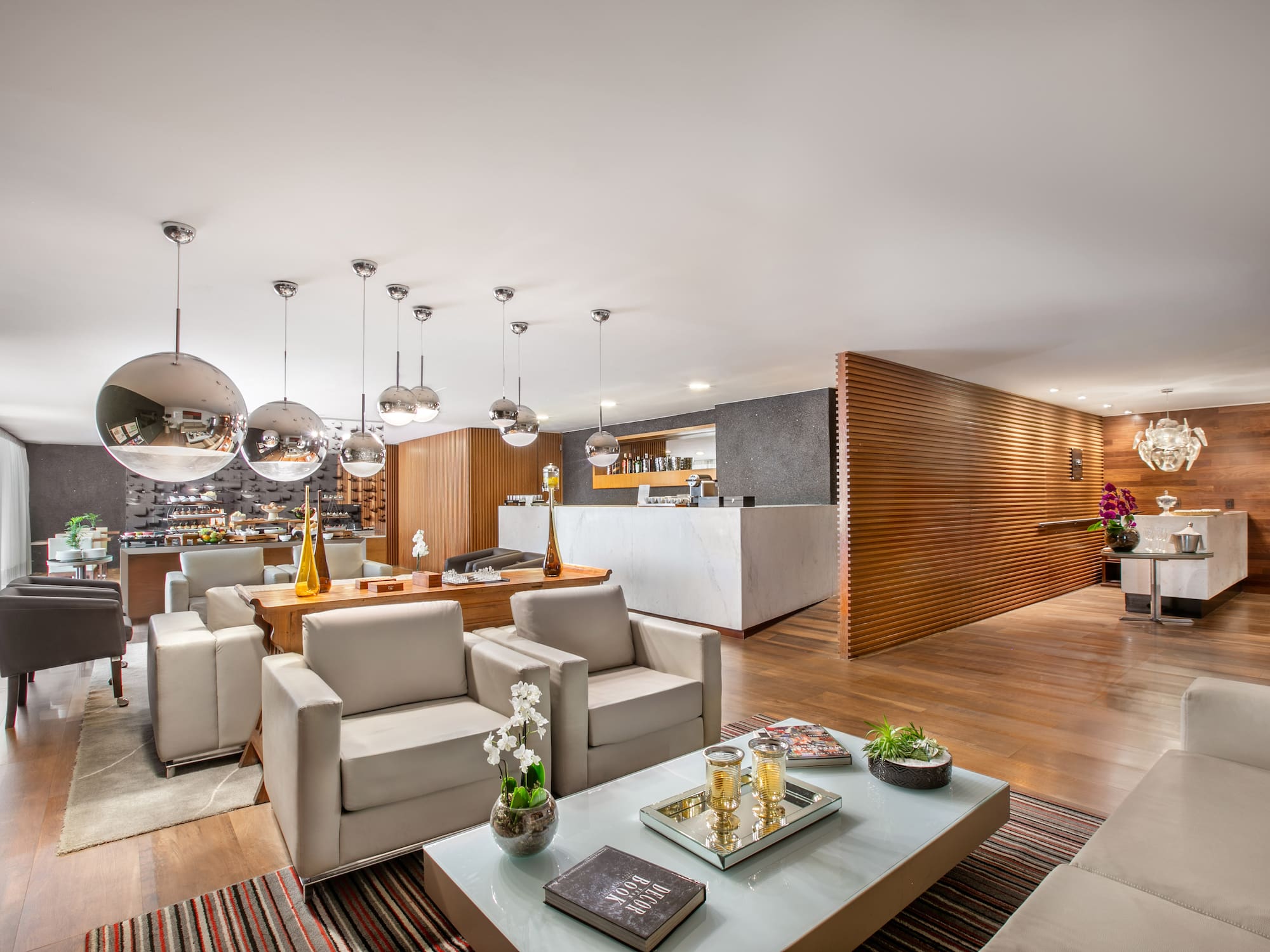Modern hotel lounge with comfortable seating, marble bar, and wooden decor.