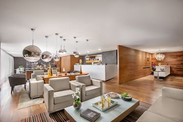 Modern hotel lounge with comfortable seating, spherical lights, and marble reception counter.