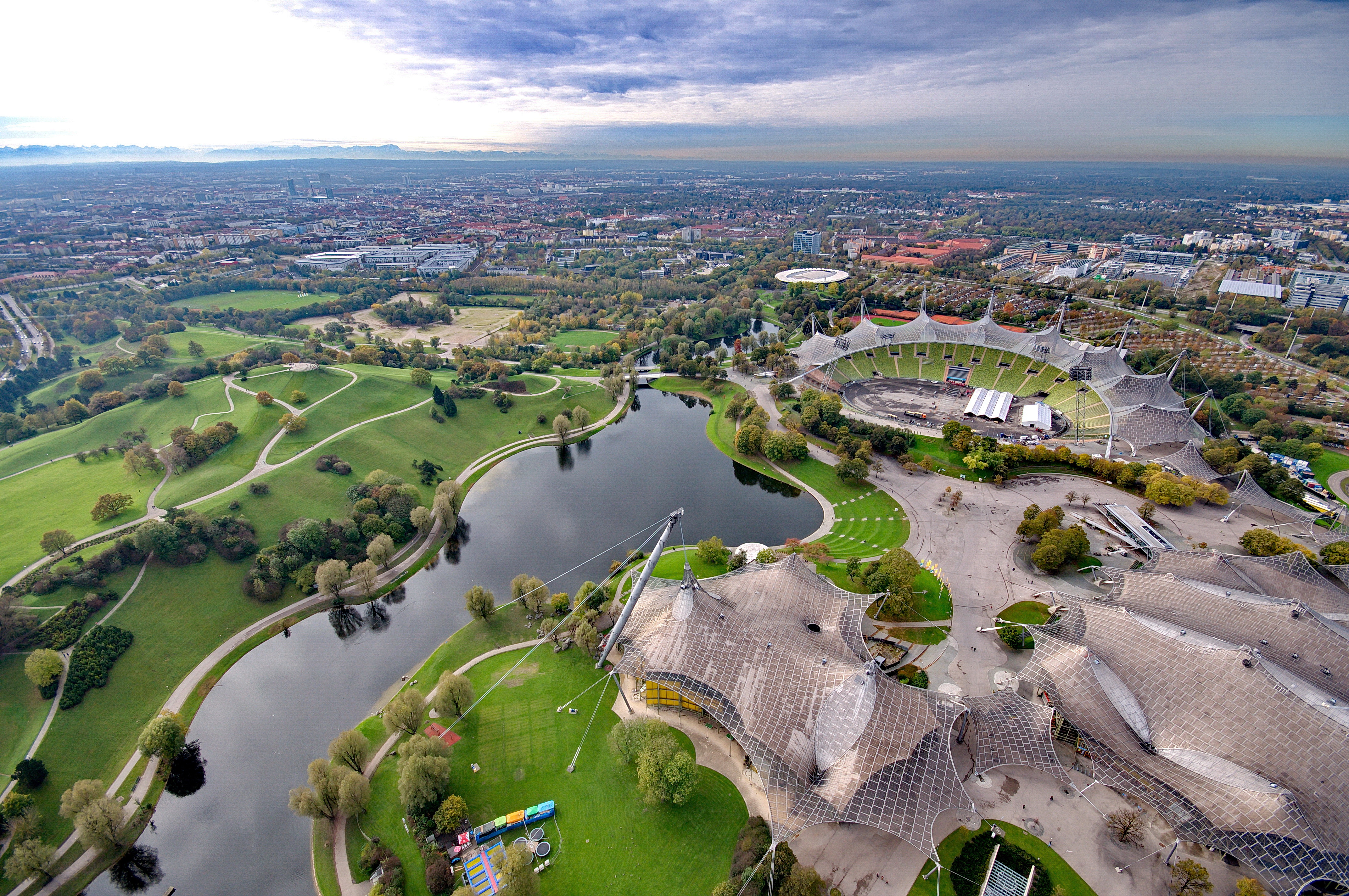 Vista aérea Olympiapark Múnich: estadio, lago y paisaje urbano.