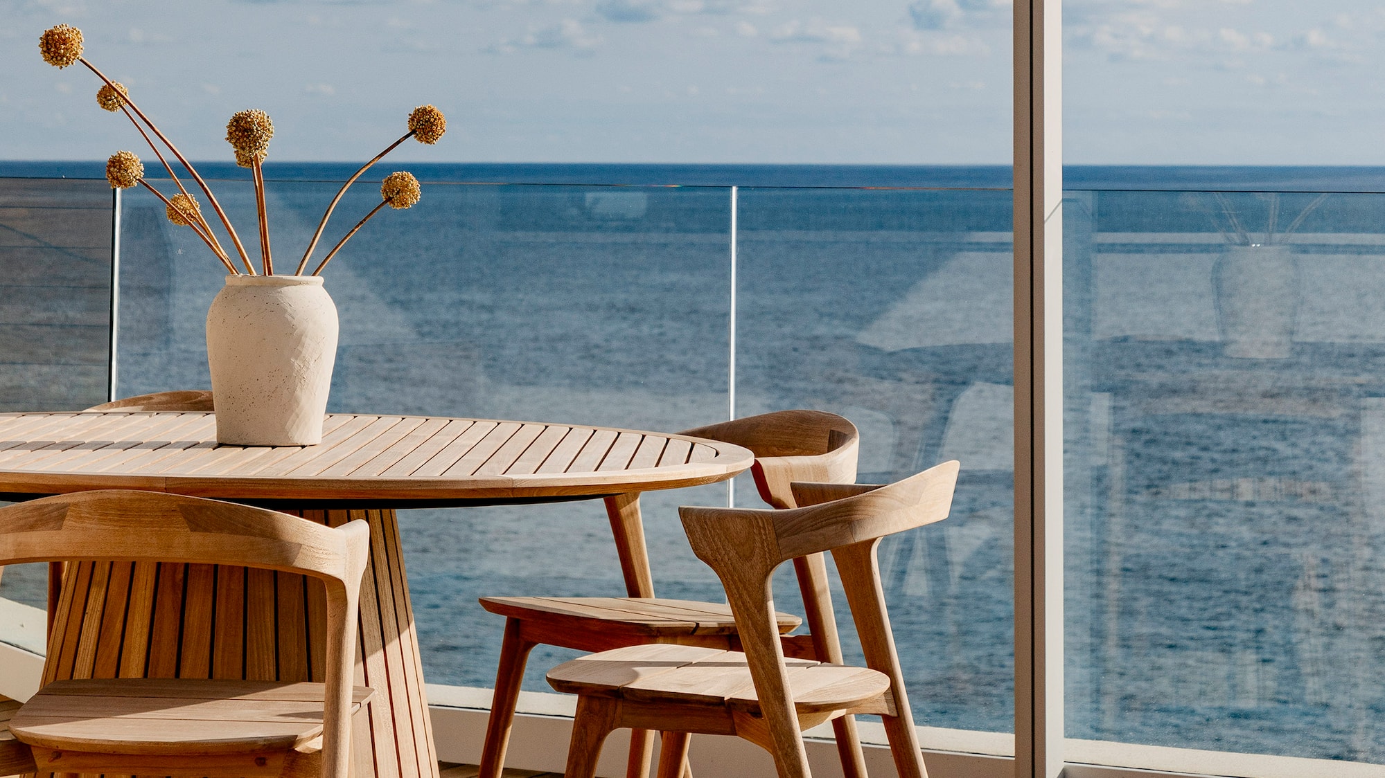 a table and chairs with a vase of flowers on it