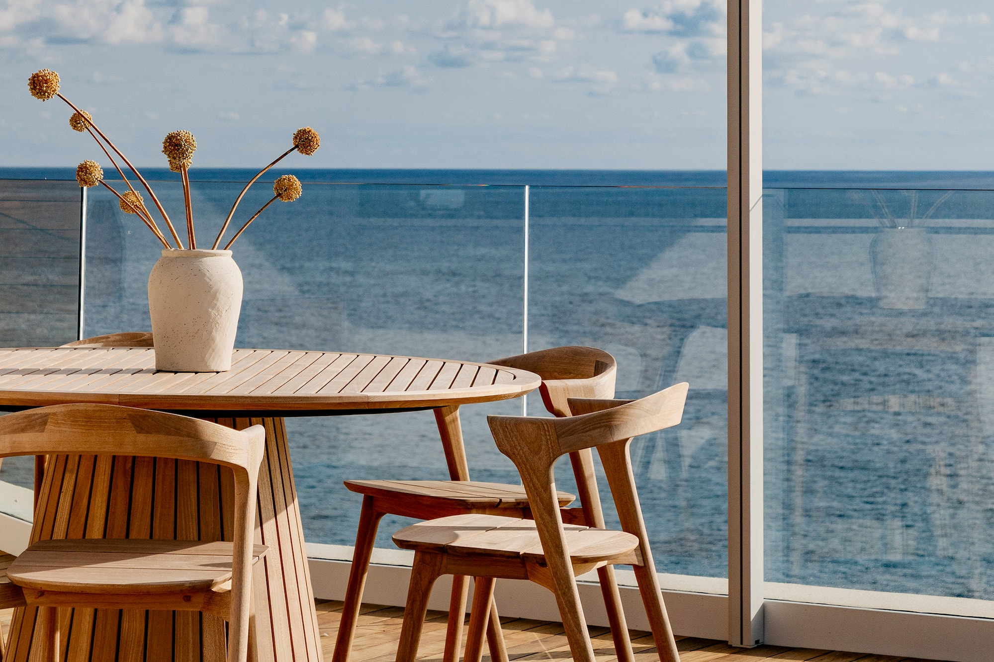 a table and chairs with a vase of flowers on it