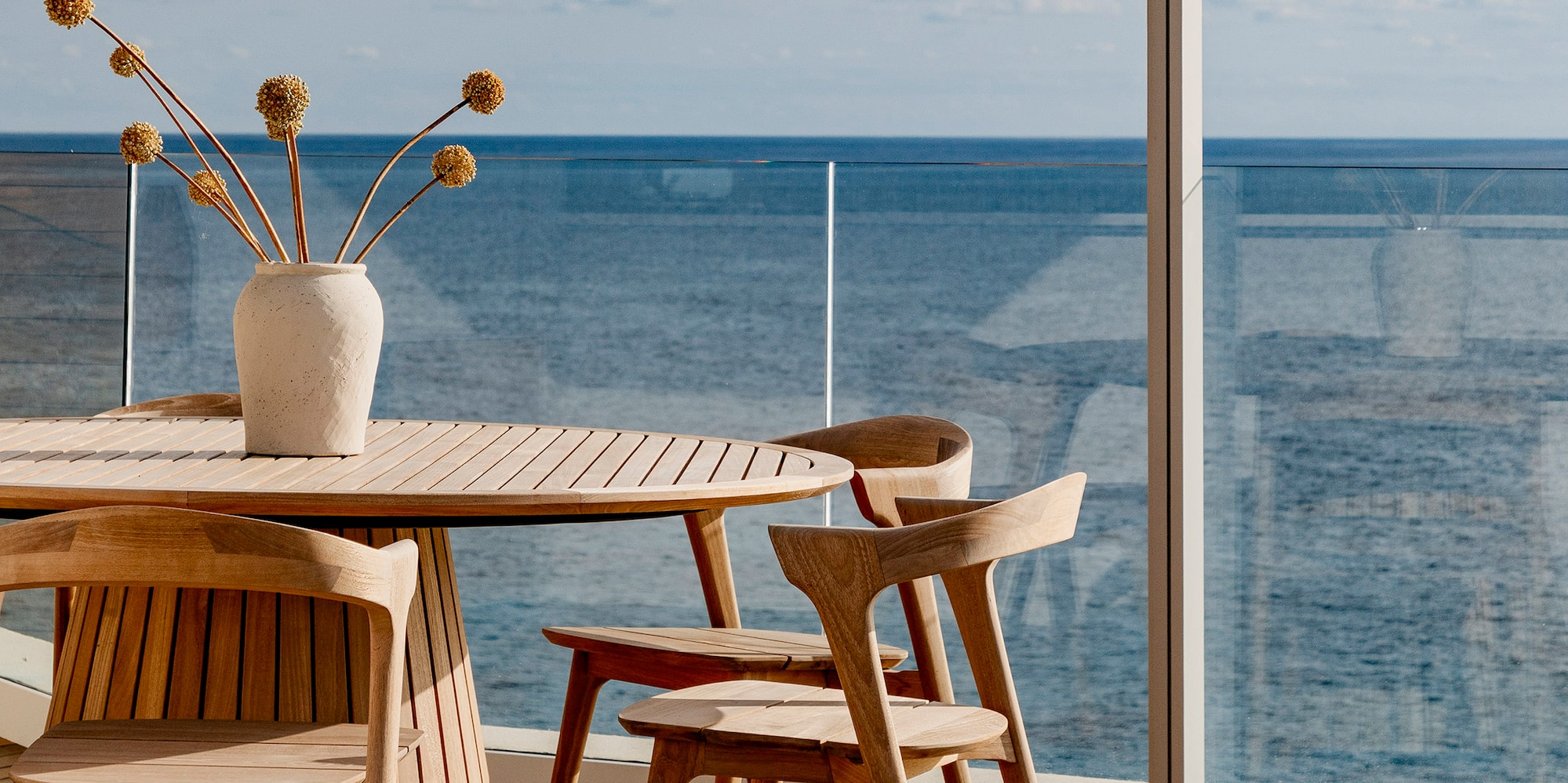 a table and chairs with a vase of flowers on it