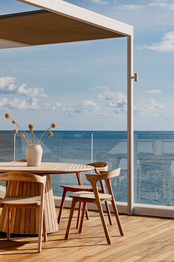 a table and chairs with a vase of flowers on it