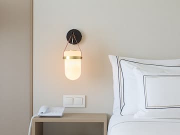 a bed with a phone and a lamp