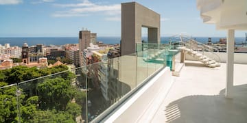 a balcony with a glass railing and a city landscape