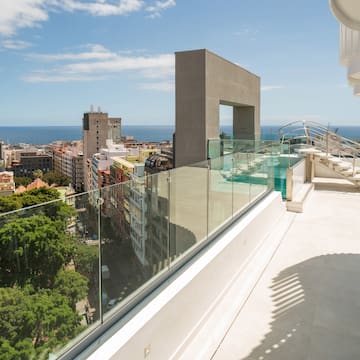 a balcony with a glass railing and a city landscape