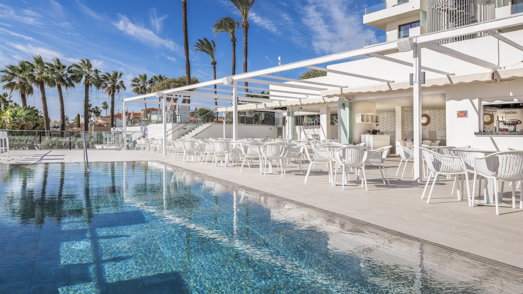 uma sala com mesas e cadeiras e vista para o mar