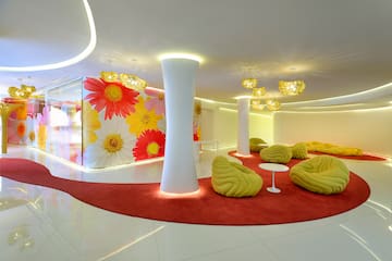 a room with a red carpet and yellow chairs