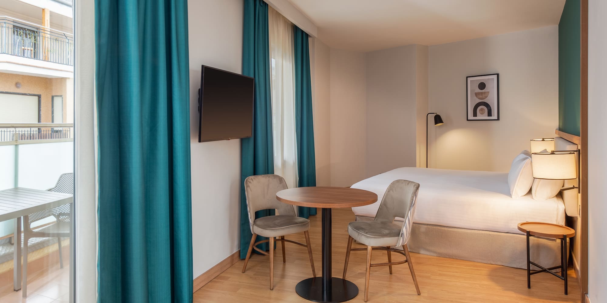 a room with a bed and a table and chairs