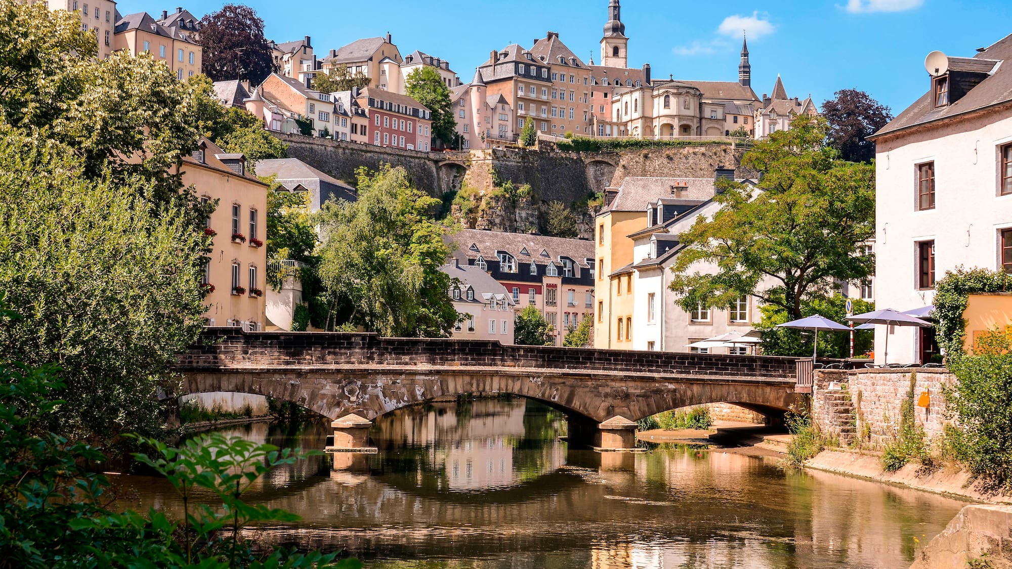 a bridge over a river with buildings in the background