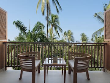 chairs on a balcony overlooking palm trees