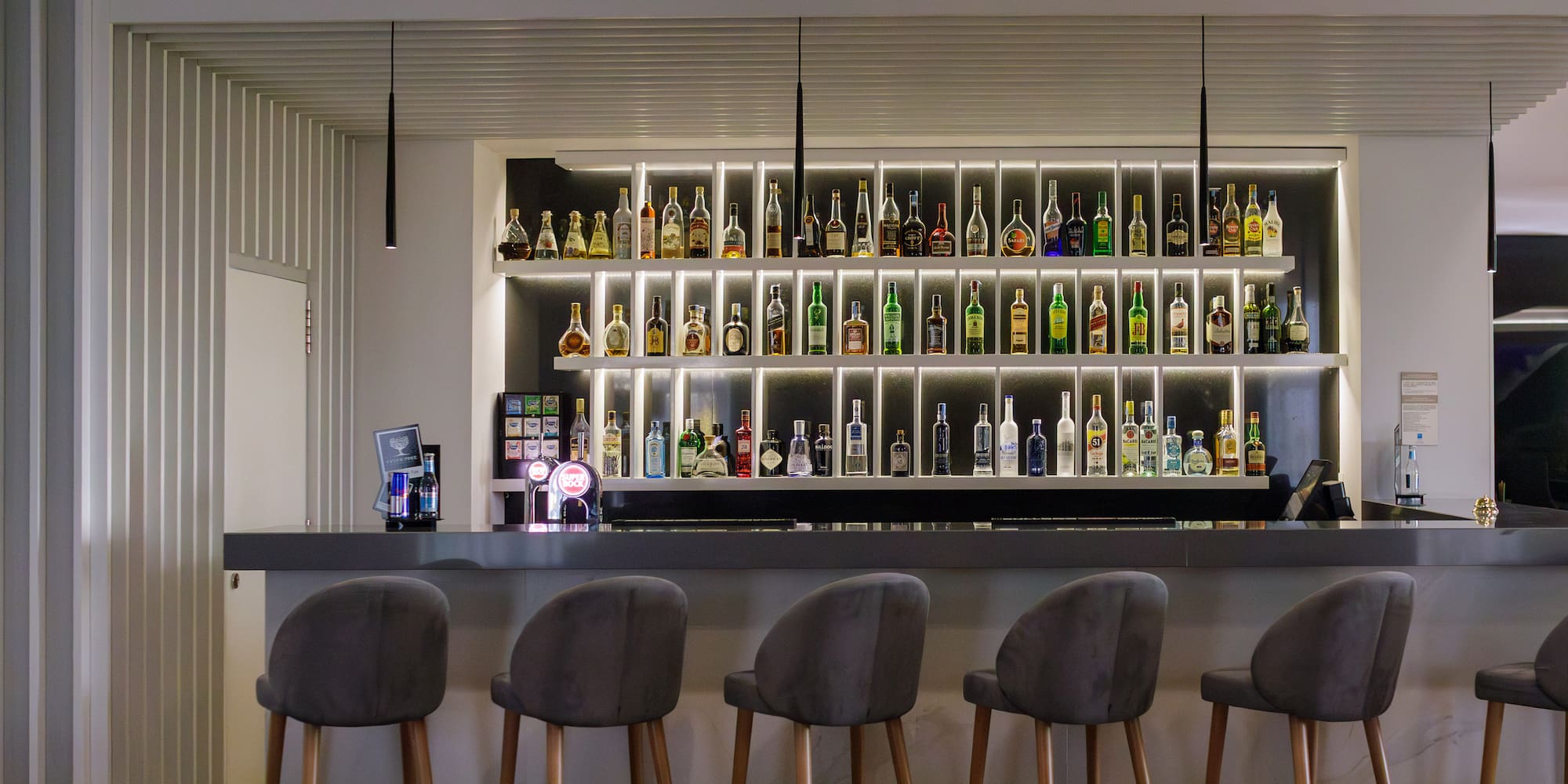 a bar with a shelf of liquor bottles