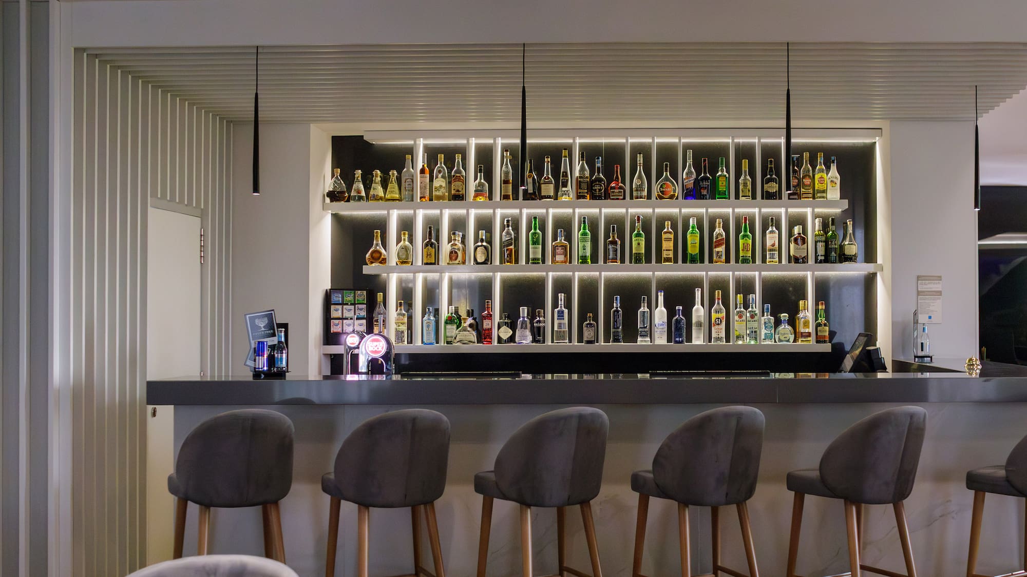 a bar with a shelf of liquor bottles
