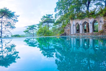 a pool with trees and a stone structure