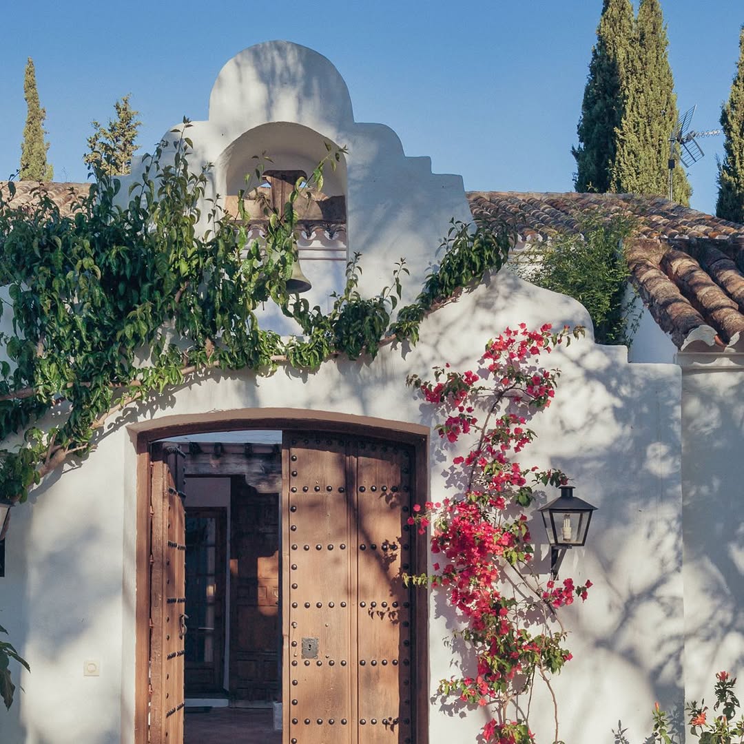 a white building with a door and a bell