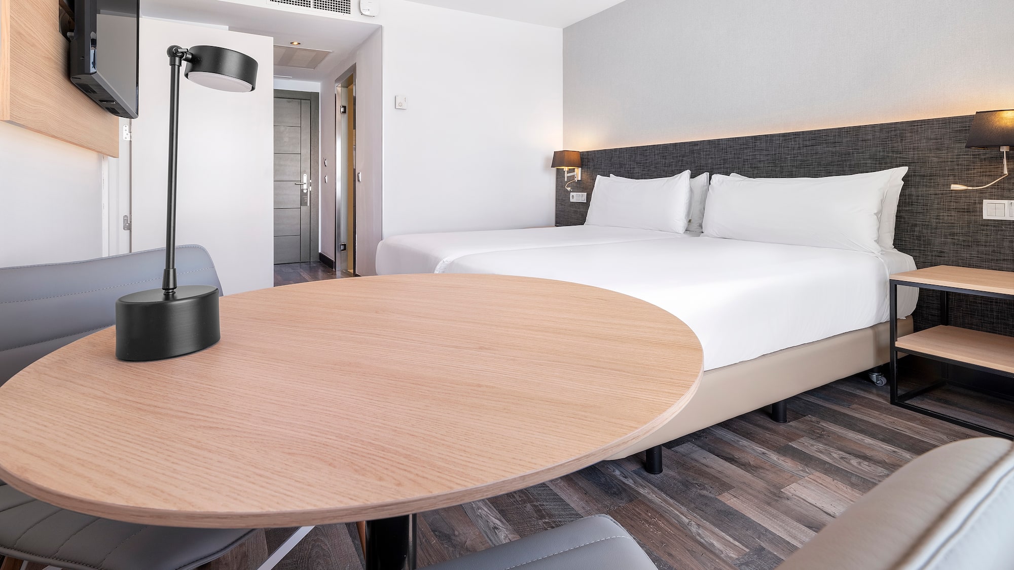 a room with a round table and a lamp