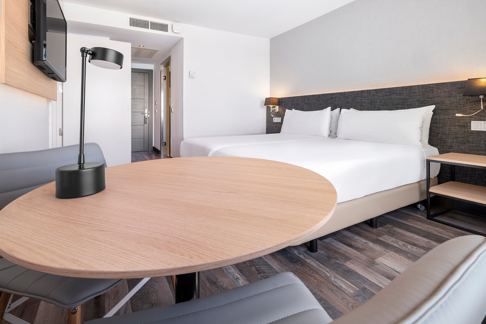 a room with a round table and a lamp