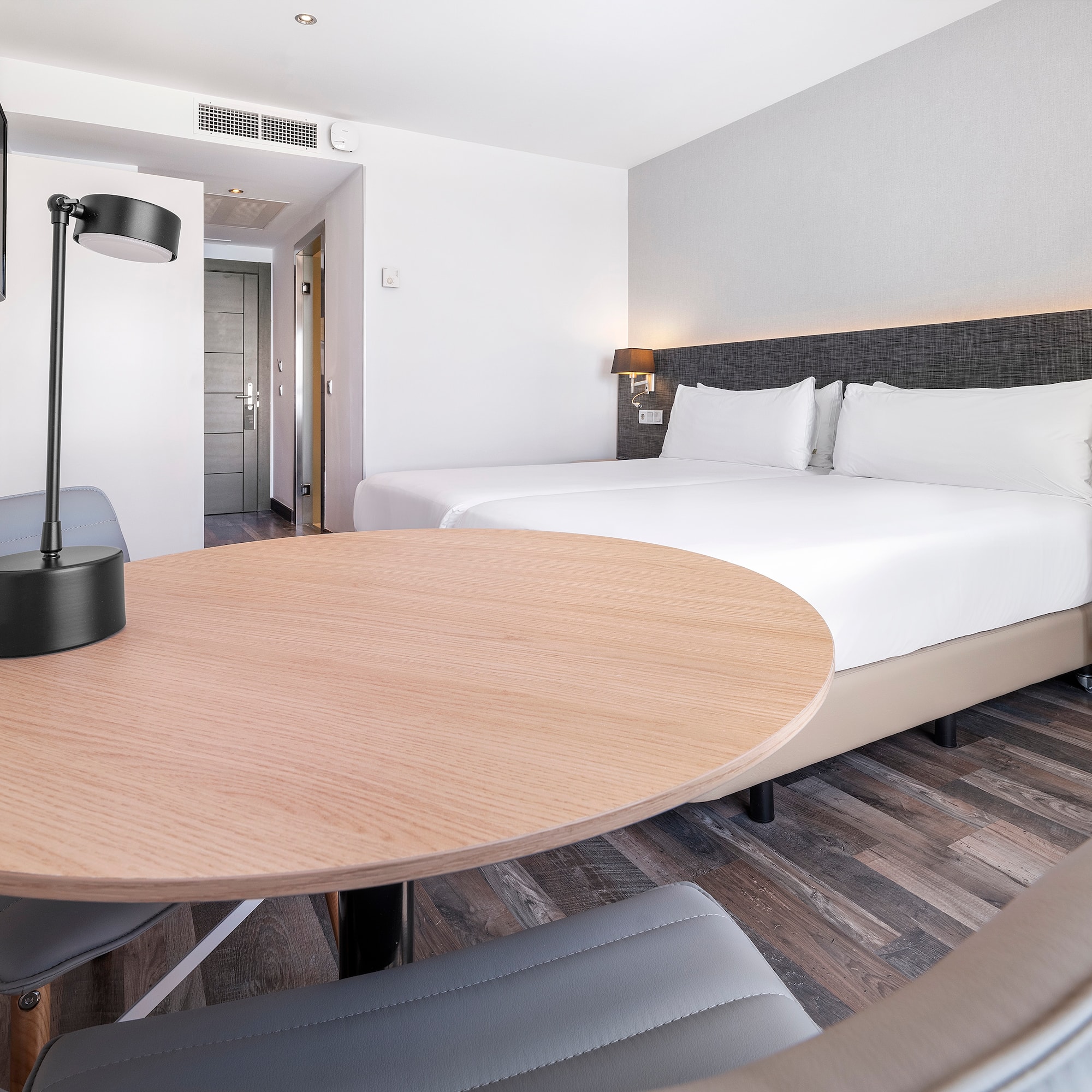 a room with a round table and a lamp