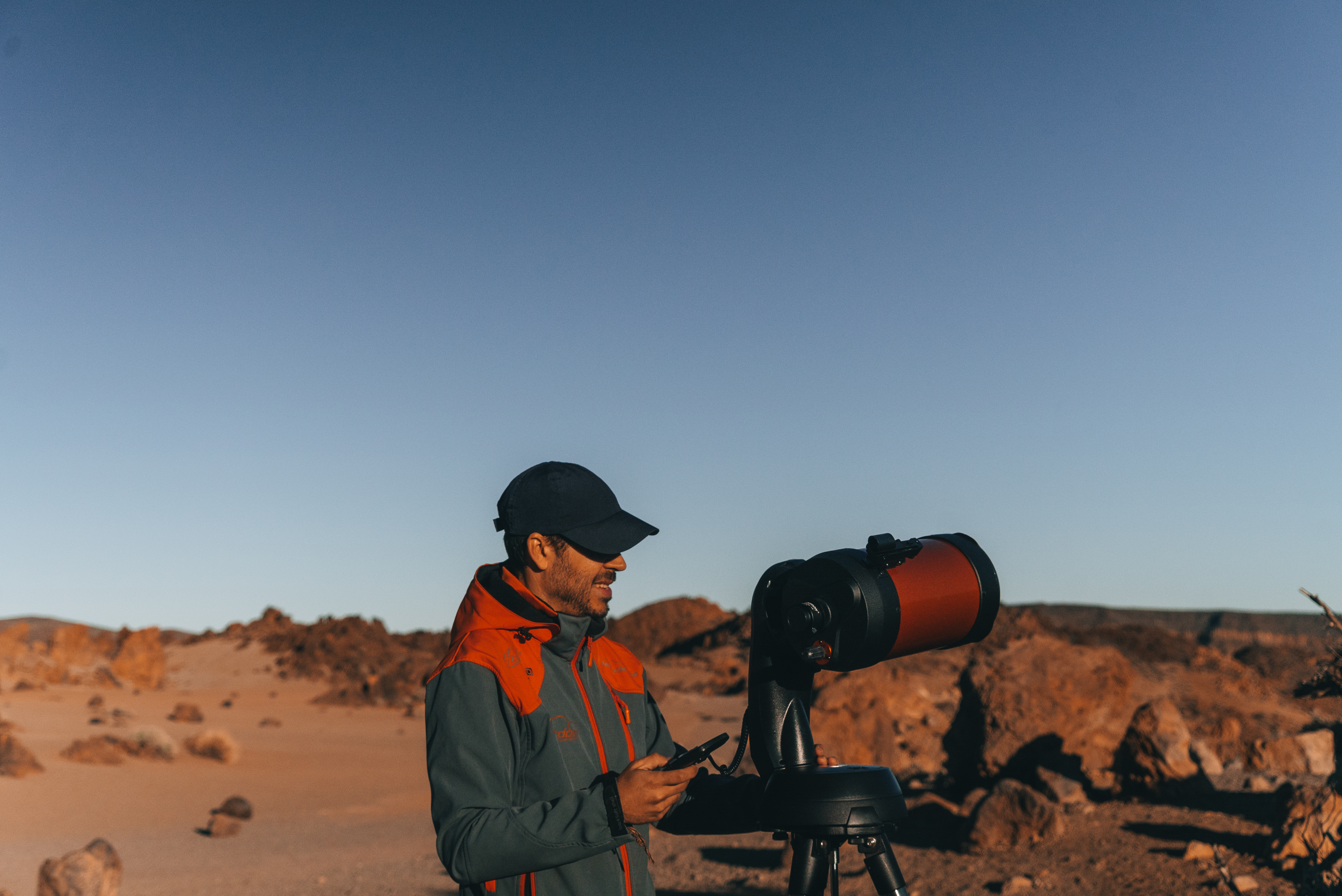 a man looking at a telescope