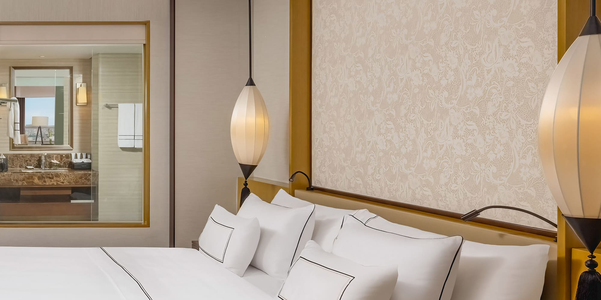 a bed with white sheets and lamps