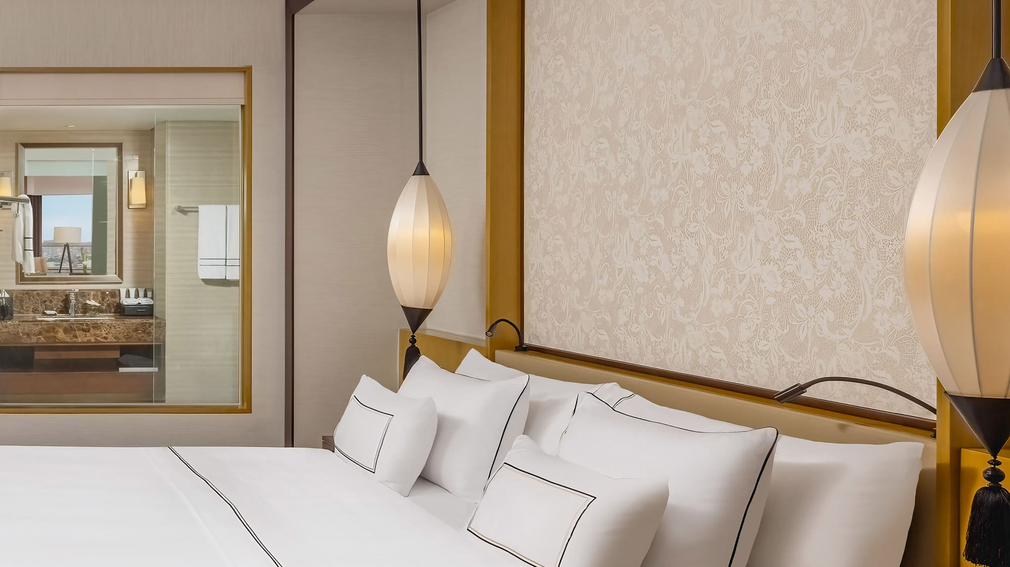 a bed with white sheets and lamps