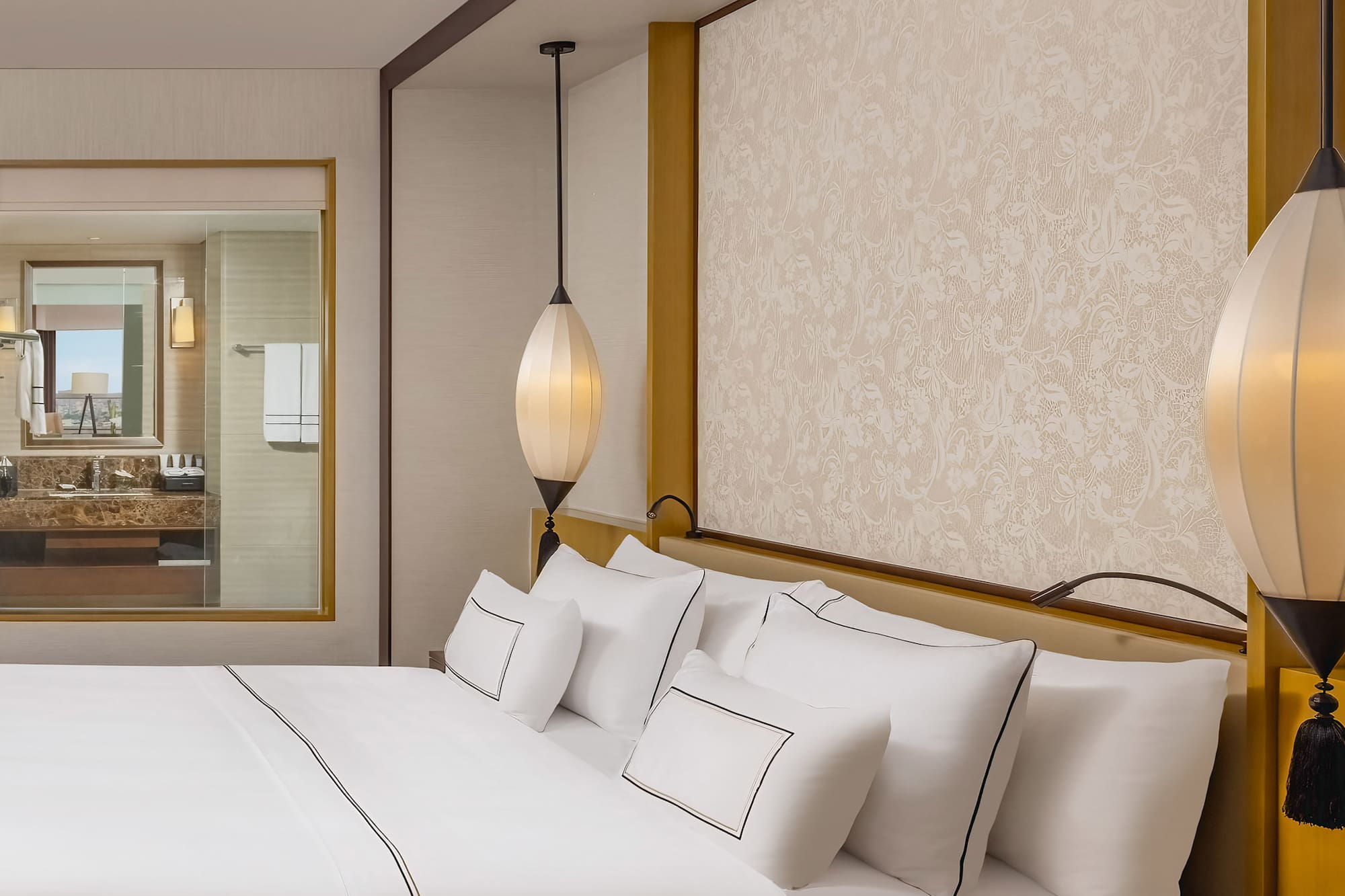 a bed with white sheets and lamps