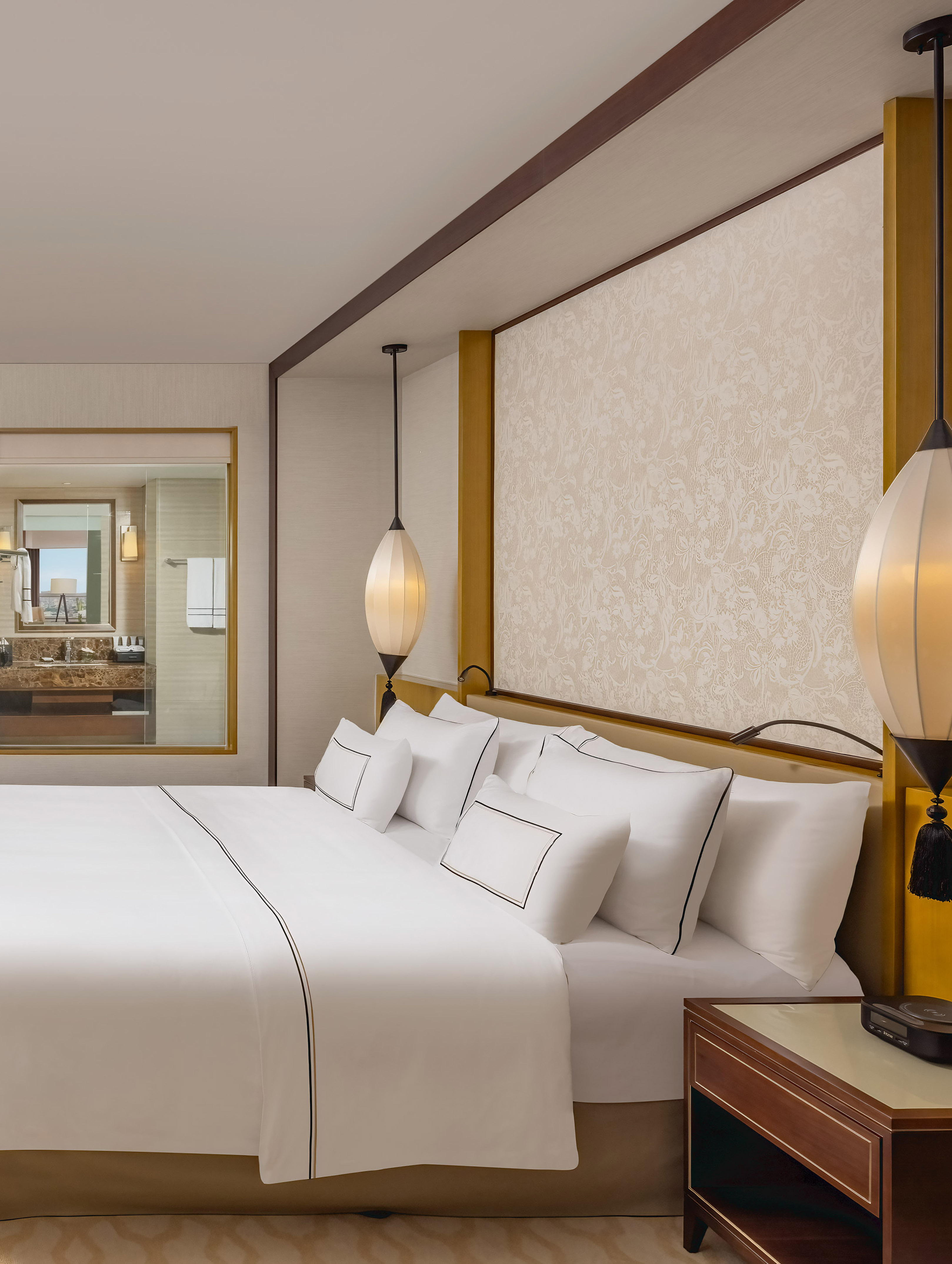 a bed with white sheets and lamps