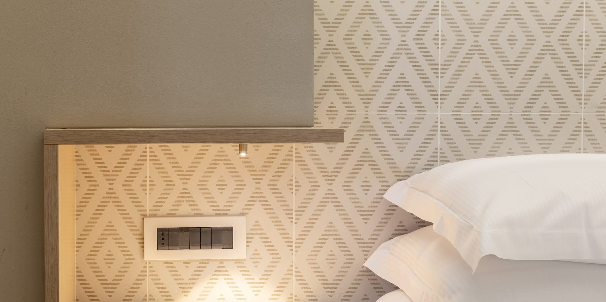 a bed with white pillows and a shelf in a room