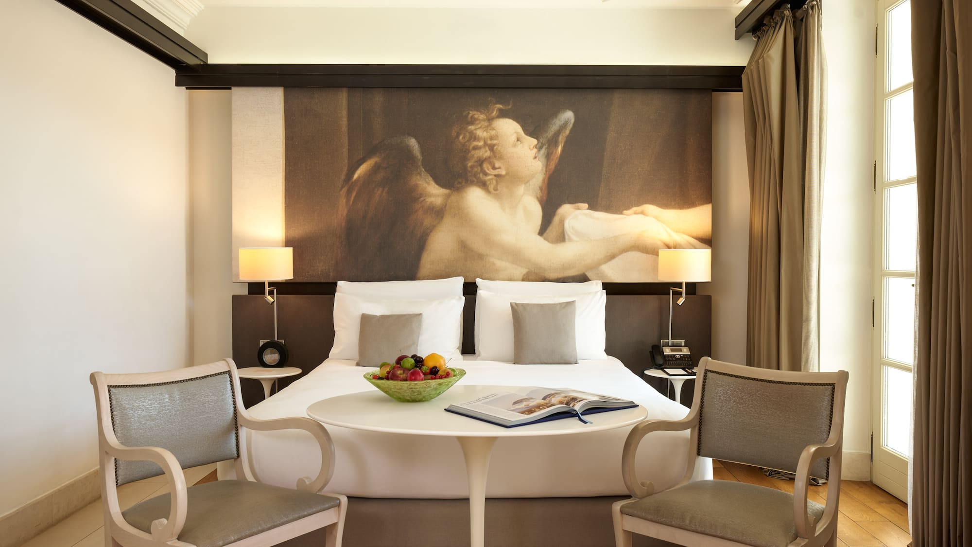 a room with a bed and chairs