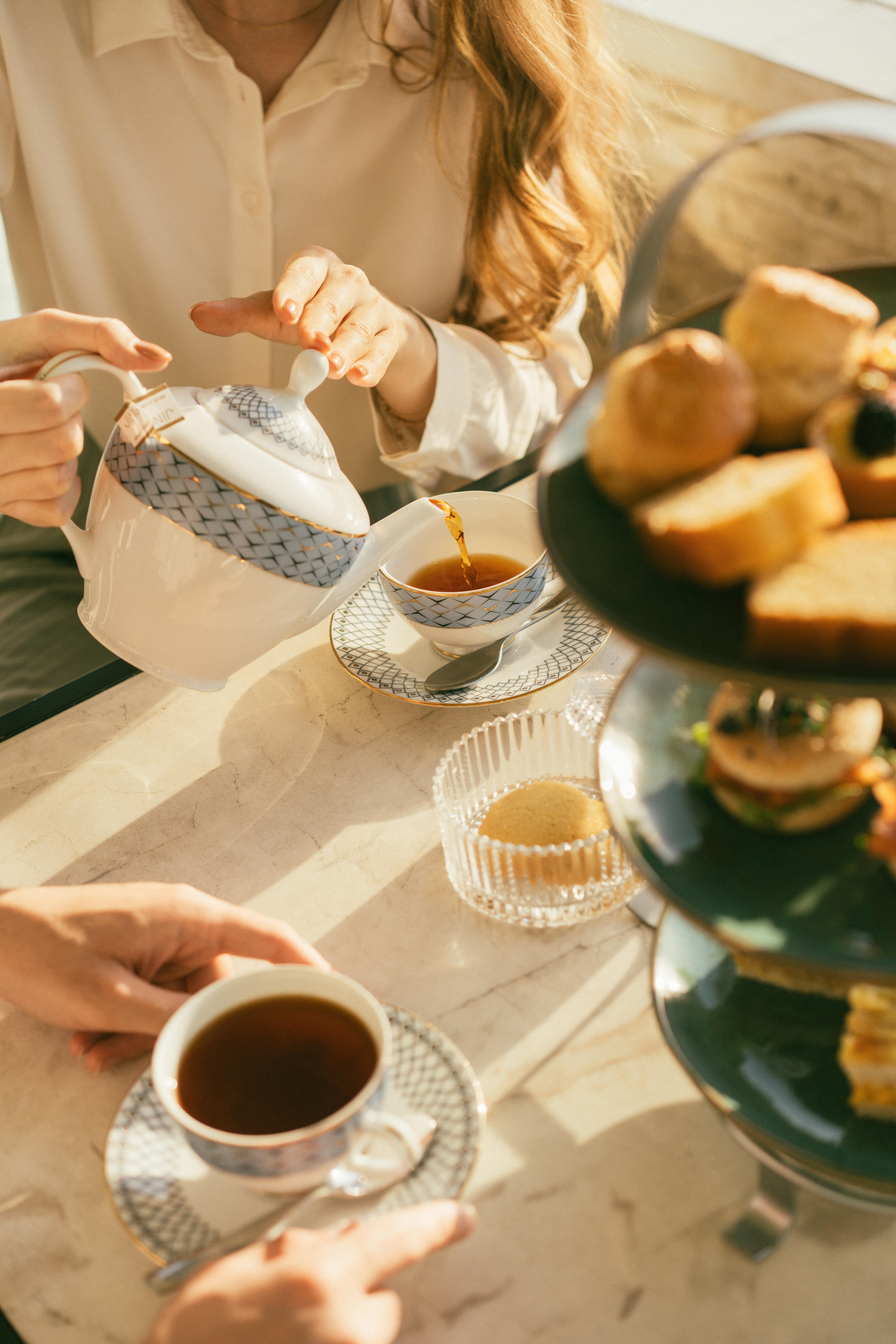 a person pouring tea into cups