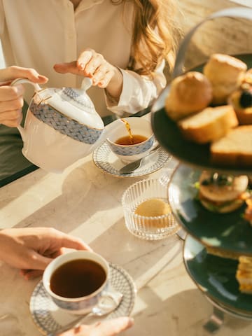 a person pouring tea into cups