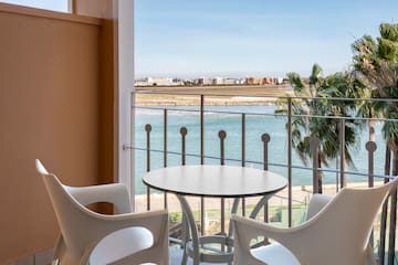 a table and chairs on a balcony overlooking a body of water