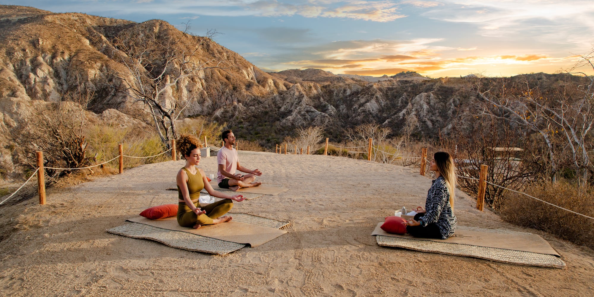 a group of people sitting on mats in a desert