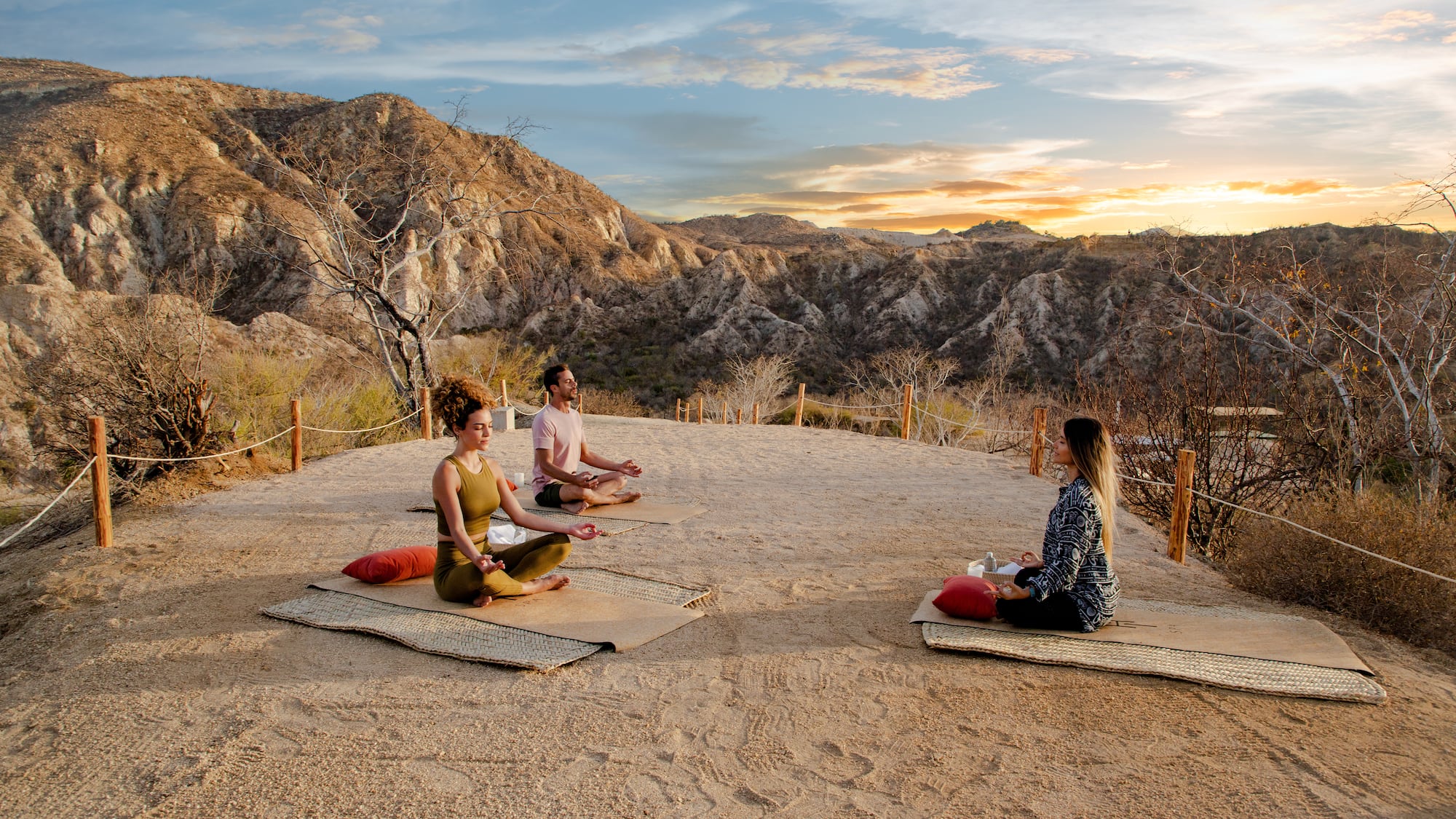 a group of people sitting on mats in a desert