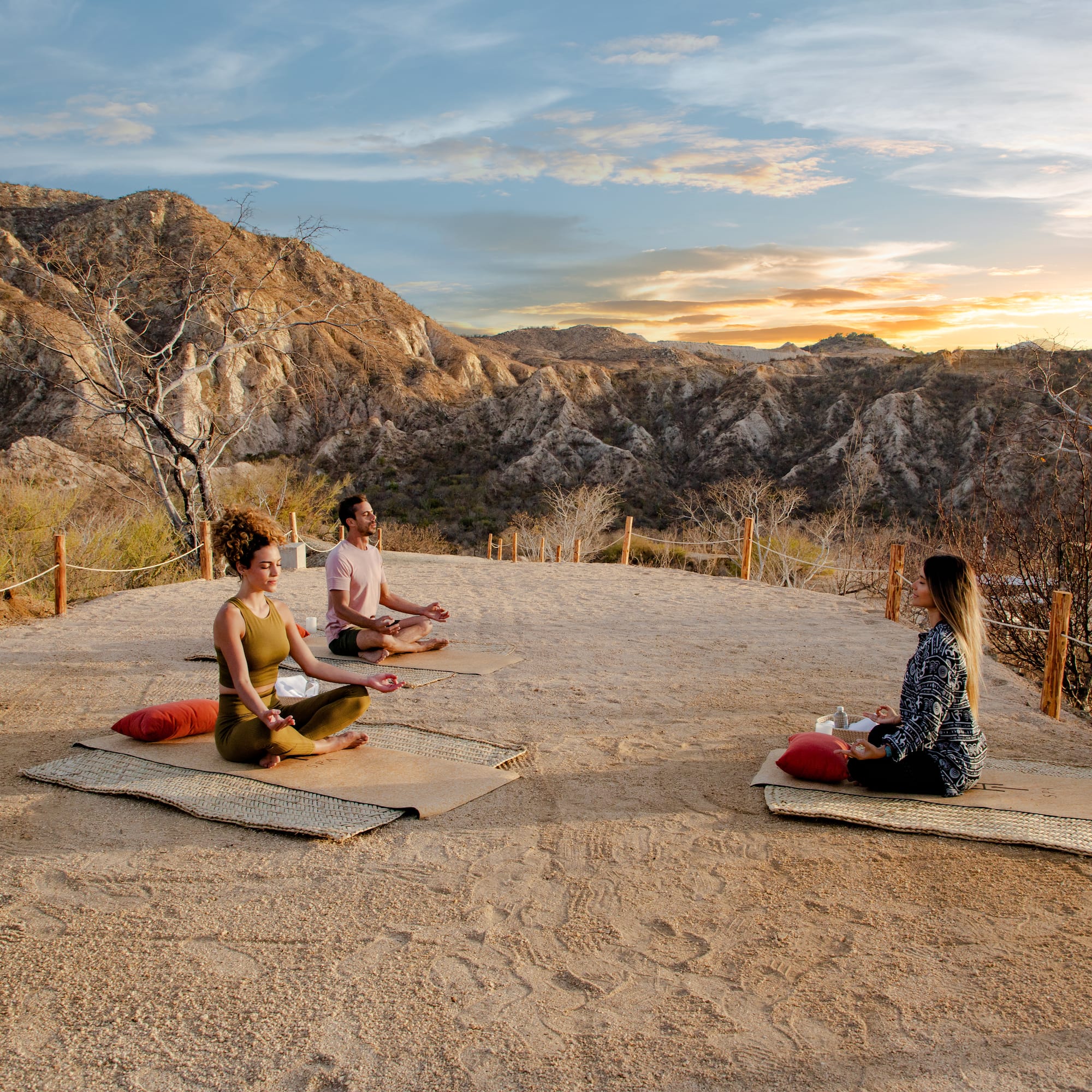 a group of people sitting on mats in a desert