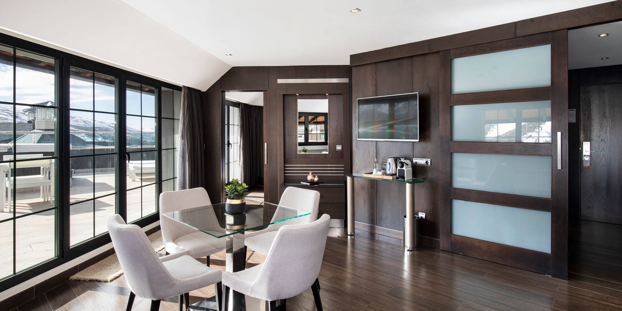 a room with a glass table and chairs