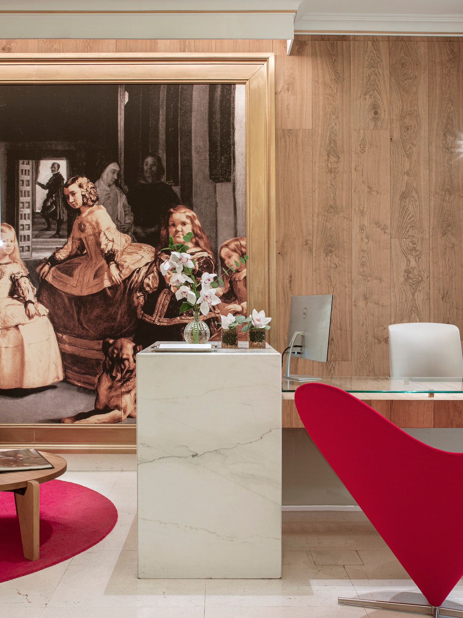 a desk in a room with a large painting on the wall