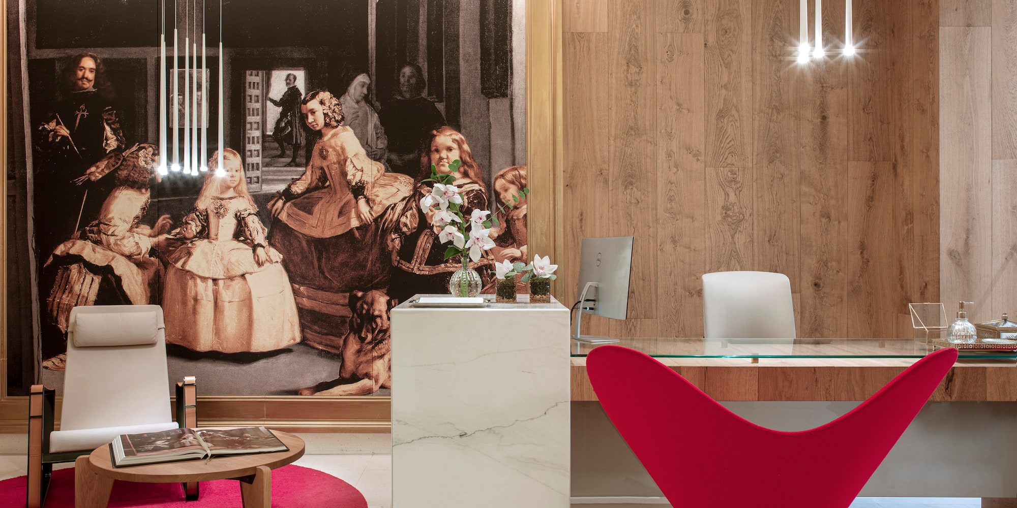 a desk in a room with a large painting on the wall