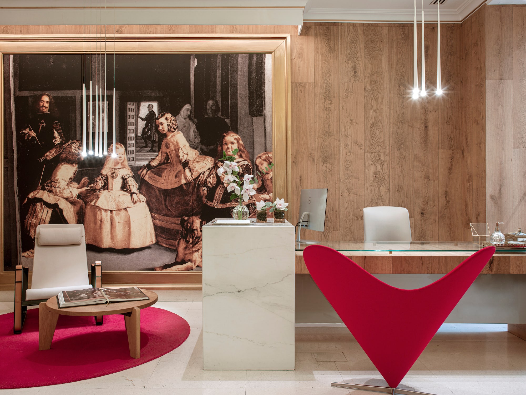 a desk in a room with a large painting on the wall